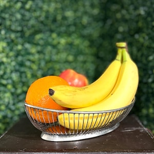 May include: A white ceramic mug with a black handle and the text "But First, Coffee" in a black, bold font. The mug is sitting on a wooden surface. The mug is 4 inches tall.