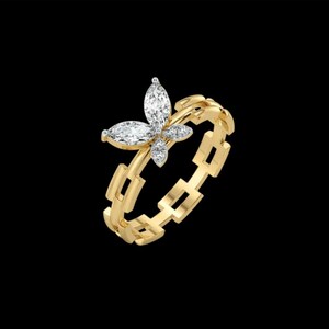 Pode incluir: Um anel de ouro com uma peça central em forma de borboleta adornada com diamantes brancos de corte marquise e redondo. A banda é composta por uma série de elos retangulares de ouro interligados, criando um aspeto de corrente no anel.