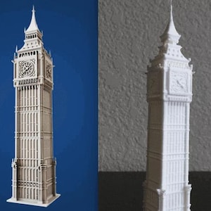 May include: A detailed, white miniature model of the Elizabeth Tower, commonly known as Big Ben. The model features intricate architectural details, including clock faces and a spire, and stands tall against a blue backdrop.