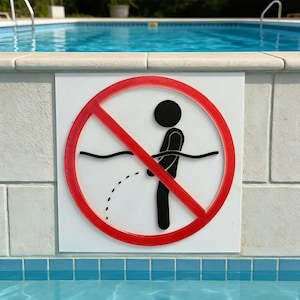 Puede incluir: Un letrero blanco con un círculo y una barra rojos, que representa a un hombrecito orinando en una piscina, con un símbolo de círculo y barra rojos encima. El letrero está montado en una pared junto a una piscina.