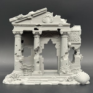 May include: A gray, miniature replica of a classical temple ruin. The structure features columns, arches, and decorative elements like seashells and coral. The temple is designed with a weathered, aged appearance.