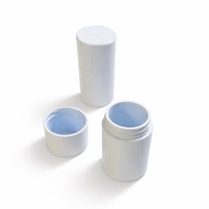 Op de afbeelding: Drie witte cilindrische containers van verschillende formaten zijn gerangschikt op een wit oppervlak. De containers omvatten een lange, gesloten cilinder, een kleine open cilinder en een grotere open pot. De binnenkanten van de open containers zijn lichtblauw.