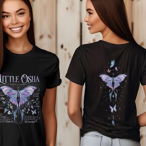 Peut inclure: T-shirt noir avec un motif de papillon d&eacute;taill&eacute; dans des tons violets et bleus, le texte "Little Osha" et d'autres textes. Le dos du t-shirt pr&eacute;sente &eacute;galement un motif de papillon. Le t-shirt est &agrave; col rond.