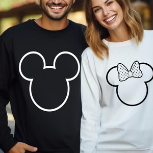 May include: Black sweatshirt with a white outline of Mickey Mouse's head. White sweatshirt with a Minnie Mouse head outline and a polka dot bow. Matching couple's apparel.