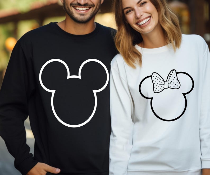 May include: Black sweatshirt with a white outline of Mickey Mouse's head. White sweatshirt with a Minnie Mouse head outline and a polka dot bow. Matching couple's apparel.