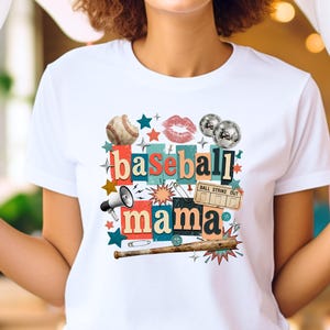 May include: White t-shirt featuring a collage design with the words "baseball mama." The design includes a baseball, lips, disco balls, stars, a megaphone, a baseball bat, and a ticket that says "ball strike out."