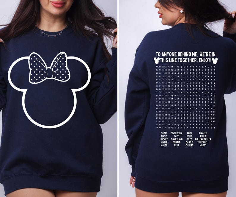 May include: Navy blue sweatshirt featuring a white Minnie Mouse outline with a polka dot bow on the front. The back of the sweatshirt has the text "TO ANYONE BEHIND ME, WE'RE IN THIS LINE TOGETHER. ENJOY!" and a word search.
