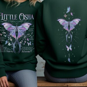 Peut inclure: Sweat-shirt vert fonc&eacute; avec un motif de papillon d&eacute;taill&eacute; en violet, bleu et rose. Le devant affiche le texte "Little Osha" et d'autres textes. Le dos pr&eacute;sente un motif de papillon similaire.