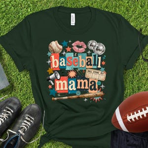 May include: Dark green t-shirt with a baseball-themed graphic. The design includes a baseball, lips, disco balls, and the words "baseball mama." A football, shoes, and a water bottle are also visible.