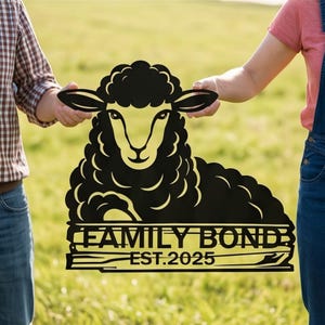May include: Black metal sheep sign with the text "FAMILY BOND" and "EST. 2025". The sign is held by two people in a grassy outdoor setting. The sheep has a curly wool design.