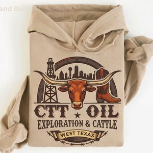 Może przedstawiać: Beżowa bluza z kapturem z grafiką przedstawiającą długorogiego bydła, but kowbojski, platformę wiertniczą i panoramę miasta. Tekst brzmi "CTT OIL EXPLORATION & CATTLE WEST TEXAS".