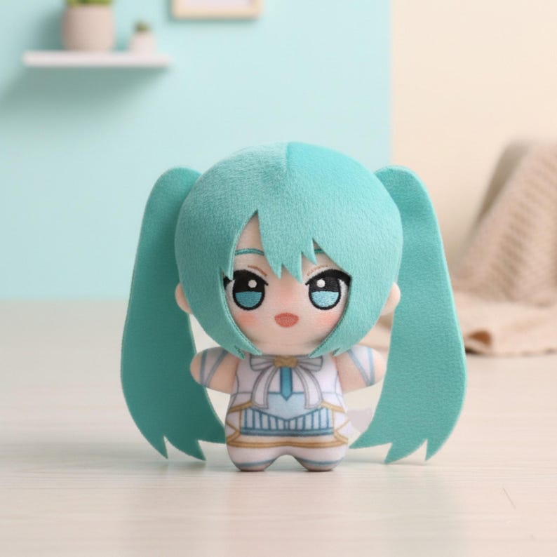 May include: A teal-haired plush doll with long pigtails. The doll has large eyes and a small mouth. It is dressed in a white and blue outfit with decorative details. The doll is standing upright.