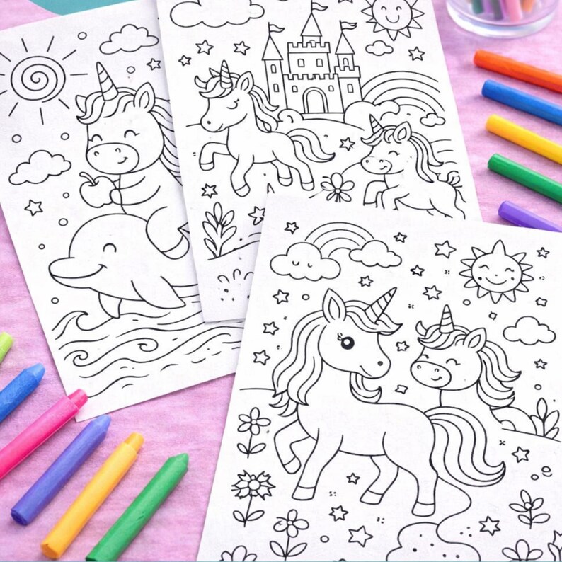 K&ouml;nnte beinhalten: Drei Ausmalbilder mit Einhorn-Motiven, einem Delphin, einer Burg, einem Regenbogen und einer Sonne. Buntstifte in verschiedenen Farben liegen um die Seiten herum, bereit zum Ausmalen. Die Illustrationen sind schwarz auf wei&szlig;em Papier.