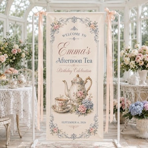 May include: A vertical cream-colored banner featuring a floral border, a teapot, and a teacup illustration. The text reads: WELCOME TO Emma's Afternoon Tea Birthday Celebration SEPTEMBER 6, 2026. The banner is suspended from a white metal frame.