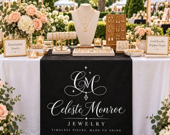 May include: A black table runner featuring the white logo CM Celeste Monroe Jewelry and the text Timeless Pieces, Made to Shine. The display includes gold necklaces on a mannequin, gold earrings on a wooden stand, gold bracelets, and rings.