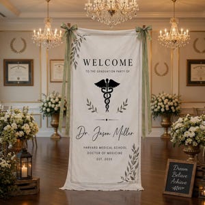 Puede incluir: Una gran pancarta blanca con texto negro y un símbolo médico, dando la bienvenida a los invitados a una fiesta de graduación. La pancarta dice "WELCOME" y "Dr. Jason Miller, Harvard Medical School, Doctor of Medicine, EST. 202X". Cintas verdes y arreglos florales decoran la habitación.