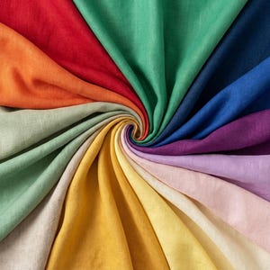 Peut inclure: Une présentation vibrante de tissu coloré disposé en spirale. L'image présente un spectre de couleurs, dont le rouge, l'orange, le vert, le bleu, le violet et le jaune, créant un design textile visuellement attrayant. Le tissu semble être du lin.