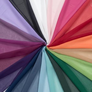 May include: A collection of sheer, lightweight fabric swatches arranged in a circular fan pattern. The colors include lavender, black, white, pale pink, magenta, red, orange, beige, light green, dark green, teal, light blue, navy, and deep purple.