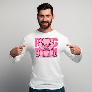 Könnte beinhalten: Weißes Langarmshirt mit einem Cartoon-Schwein-Design und dem Text "PIG TOWN" in Rosa. Das Schwein ist rosa und lächelt. Das Shirt wird von einer Person getragen.