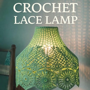 May include: A handmade green crochet lace lamp. The lamp features a detailed, openwork shade with a floral pattern. The text "CROCHET LACE LAMP" is displayed on the image. The lamp is on a green base, and the light shines through the shade.