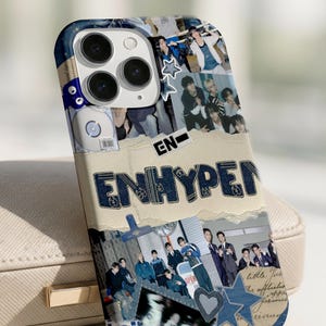 May include: A phone case with a collage design, featuring the word "ENHYPEN" in denim-style lettering. The case has a blue and beige colour scheme with various images and star accents.