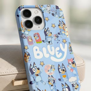 Peut inclure: Coque de téléphone bleu clair avec le mot "Bluey" en blanc, entouré d'illustrations de personnages de Bluey et d'étoiles jaunes. La coque a une finition brillante et une découpe pour l'appareil photo.