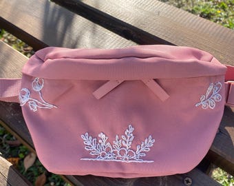 Fanny pack with hand-embroidered flowers.