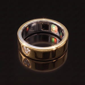 Beautiful Oura Ring Gen 5 jewelry cover in solid 14K gold with a matte finish and decorative diamond-cut design. This premium smart ring accessory creates a luxurious layered look, making your wearable ring appear like a custom fine jewelry band.