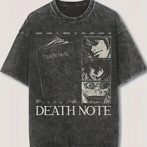 Op de afbeelding: Donkergrijze Death Note grafische t-shirt. De voorkant heeft een boek met de titel "Death Note" en drie karakterportretten. De tekst "Whose name is written in this note shall die" staat boven het boek.