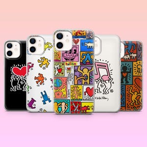 May include: Five smartphone cases featuring Keith Haring's iconic pop art designs. The cases display various colorful patterns, including dancing figures, hearts, and musical notes, with some designs signed Keith Haring. Each case has a dual-lens camera cutout.