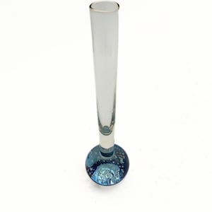 May include: A clear glass bud vase with a flared top and a round, blue base. The base is decorated with small bubbles, adding a decorative touch. The vase is approximately 8 inches tall.