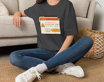 Peut inclure: Un t-shirt gris anthracite à manches courtes avec un graphique représentant une fenêtre d'erreur informatique. Le texte indique : ModuleNotFoundError : No module named 'sleep'. Did you mean : 'coffee' ? Inclut un triangle jaune.