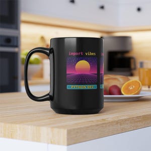 May include: A black ceramic mug featuring a graphic print with the text import vibes and PYTHON DEV. The design displays a retro-style sunset over a digital grid landscape against a starry purple and dark blue sky background.