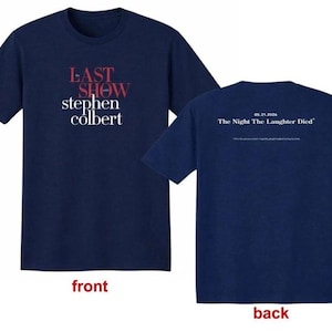 May include: Navy blue t-shirt with the text "LAST SHOW stephen colbert" in red and white on the front. The back of the shirt has the text "05.21.2026 The Night The Laughter Died".