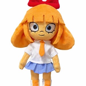 Peut inclure: Poupée en peluche avec des cheveux orange et un nœud rouge. La poupée porte une chemise blanche, une jupe bleue et une cravate orange. Les chaussures de la poupée sont blanches avec des détails orange. La poupée a de grands yeux bleus et un sourire.