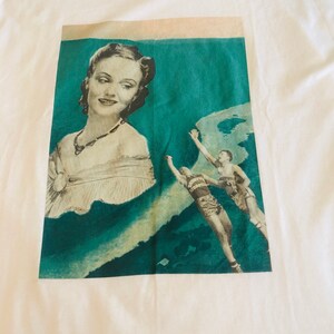 May include: A printed fabric featuring a vintage design. The design includes a portrait of a woman in grayscale, set against a teal background with basketball players. The fabric is on a white background.