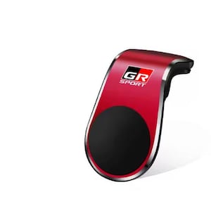 May include: A red and black car phone mount with the text "GR SPORT". The mount has a black circular area for holding a phone and a silver trim.