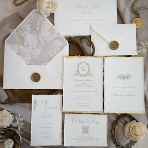 Könnte beinhalten: Elegante Hochzeitseinladungs-Suite mit weißen Karten mit Goldakzenten und floralen Details. Enthält Umschläge, RSVP-Karten und Detailkarten. Die Einladung ist mit einem floralen Muster verziert und mit einem Wachssiegel versehen, perfekt für ein stilvolles Event.