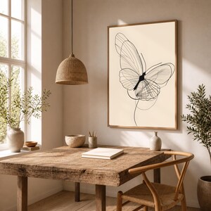 May include: A framed wall art print featuring a black line drawing of a butterfly on a cream-colored background. The butterfly illustration consists of delicate, overlapping lines that form the wings and body, displayed in a simple wooden frame.