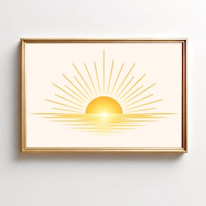 May include: A framed wall art print featuring a stylised yellow sun rising over a horizontal line, with radiating sunbeams extending upwards and a series of horizontal lines below the sun creating a reflection effect on a light cream background.