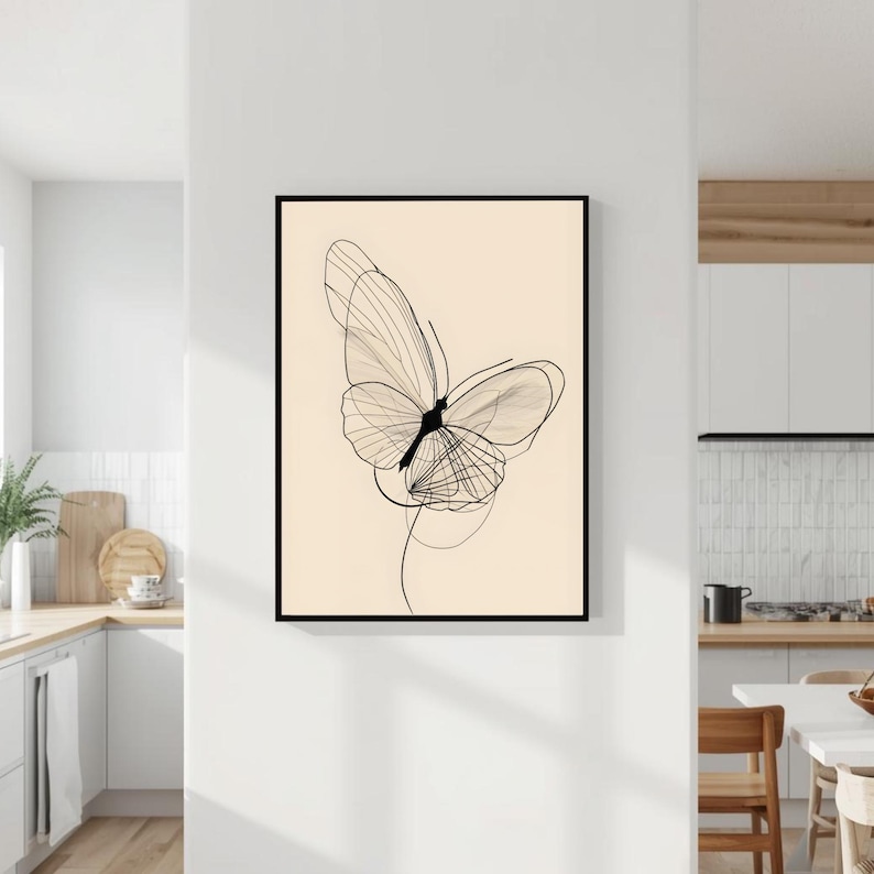 May include: A framed wall art print featuring a black line drawing of a butterfly on a solid light beige background. The butterfly illustration is composed of thin, overlapping lines that create a delicate, translucent appearance with a dark body.