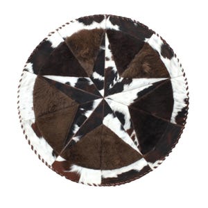 May include: A round cowhide rug with a star design. The rug features a star pattern in shades of brown, black, and white. The edges are trimmed with a brown stitched border. This decorative rug is suitable for a living room or bedroom.