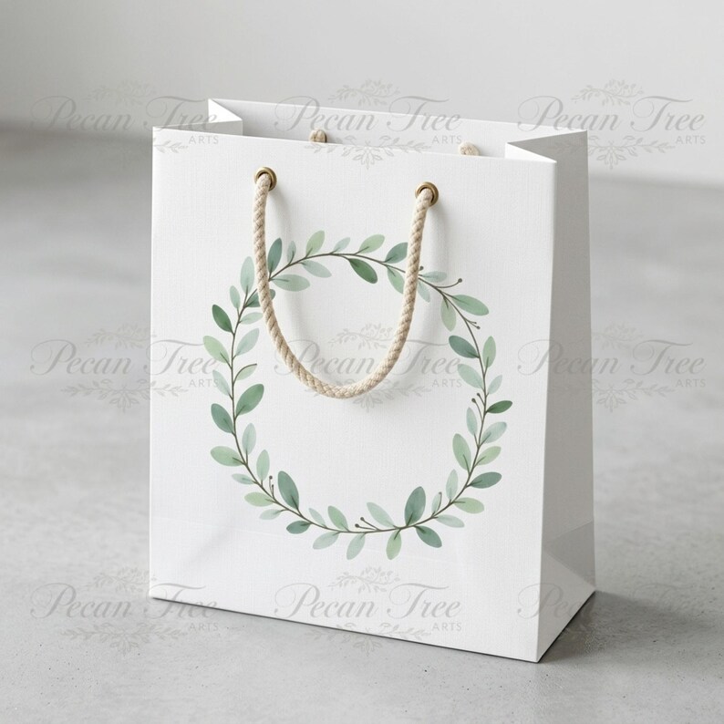 May include: A white gift bag with a watercolor wreath design. The wreath is composed of green leaves and stems. The bag has a rope handle and gold-colored eyelets. The bag is a square shape.