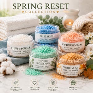 May include: Five clear plastic jars filled with colourful laundry salt sizzlers from the Spring Reset Collection. Scents include Fluffy Towels, Blue Skies, Cashmere Glow, Frosted Eucalyptus, and White Musk & Golden Maple. Each jar features a label with the scent name and the text Laundry Salt Sizzlers Wax Melt Alternative.