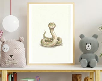 May include: A framed watercolor print of a friendly snake in shades of green and tan. The snake is coiled and smiling, set against a cream-colored background. The artwork is displayed on a white shelf with children's toys and books.