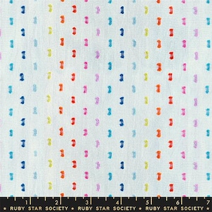 May include: White fabric with a repeating pattern of colorful, textured dashes in blue, orange, pink, yellow, and green. The fabric has a subtle, speckled texture. The bottom of the image has a ruler with the text "RUBY STAR SOCIETY".