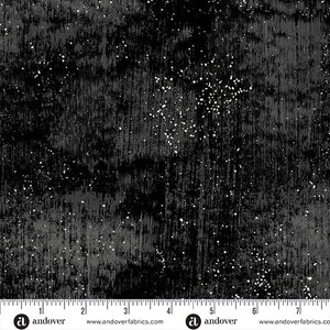 May include: Black and gray fabric with a textured, distressed appearance. The fabric has vertical streaks and scattered white speckles, creating a starry or speckled effect. The Andover Fabrics logo is visible at the bottom.