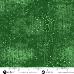 May include: Green fabric with a textured, distressed appearance. The fabric has vertical lines and small white speckles, creating a rustic, aged look. The bottom of the fabric has a ruler with the brand name "andover" and website address.