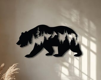 Puede incluir: Arte de pared de oso de metal negro con una escena de bosque recortada dentro de la silueta del oso. El oso camina hacia la izquierda. El arte de pared está montado en una pared de color neutro.