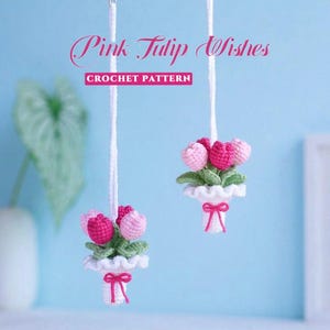 Puede incluir: Dos adornos de ganchillo colgantes con pequeños ramos de tulipanes rosas y rosa oscuro con hojas verdes, envueltos en papel blanco con volantes atado con un lazo rosa. El texto Pink Tulip Wishes CROCHET PATTERN aparece en rosa y blanco.